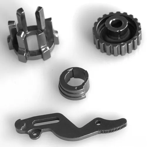 Metal mechanical components including a gear, a toothed lever, and two circular parts on a white background
