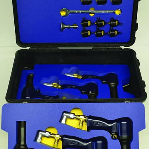 Open black case with blue foam insert holding multiple black and brass metal tools organized inside.