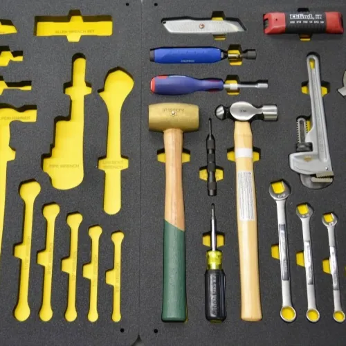 Organized foam tool case with a hammer, wrenches, screwdrivers, and other hand tools on a yellow background