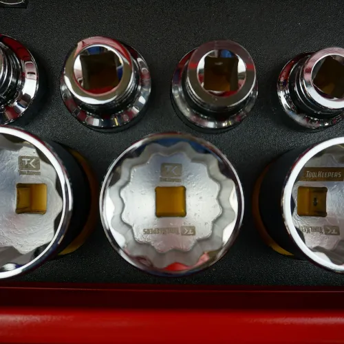 Set of shiny chrome socket wrenches with square drive holes organized in a red toolbox.