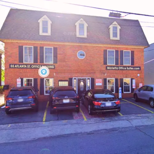 Brick office building with black shutters and parking lot in front at 55 Atlanta St, Marietta