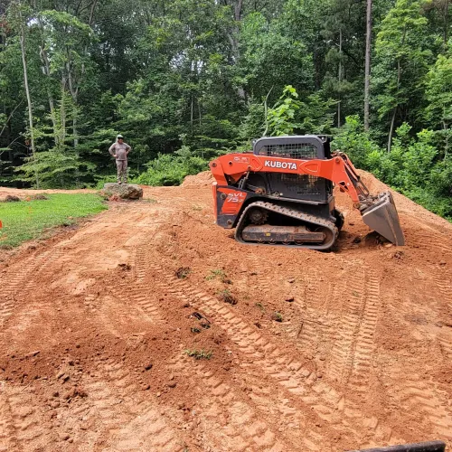 a red truck driving on a dirt road in the woods