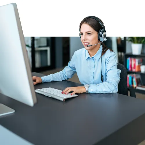 a person wearing headphones and sitting at a desk with a computer