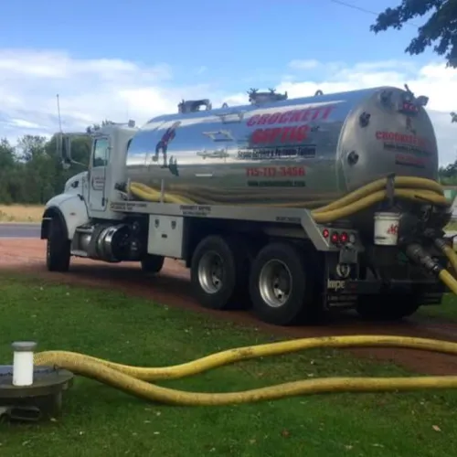 Crockett Septic truck parked, ready for septic pumping services with hoses visible on the ground.