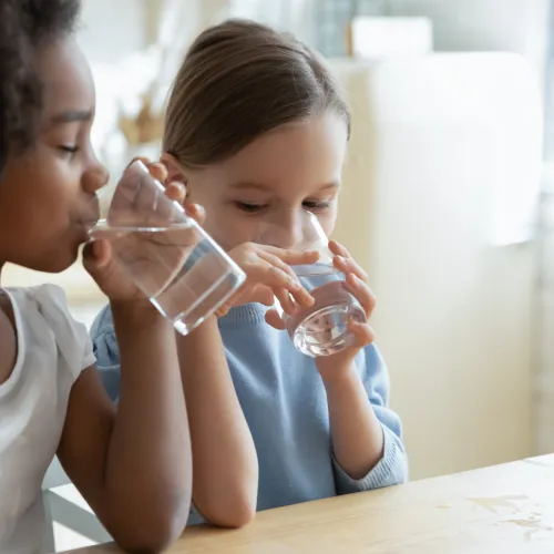 a woman and a child drinking from a bottle