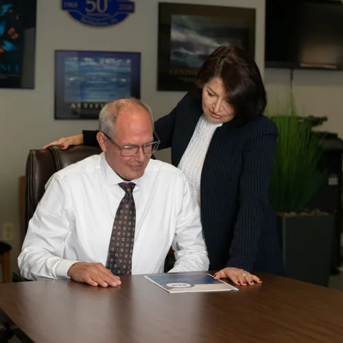Business professionals reviewing a document together at a conference table in an office setting.