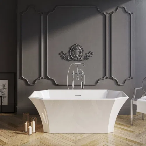 Modern white freestanding bathtub in a minimalist gray bathroom with decorative wall panel and transparent chair.