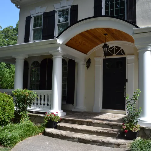 a white house with pillars and a door