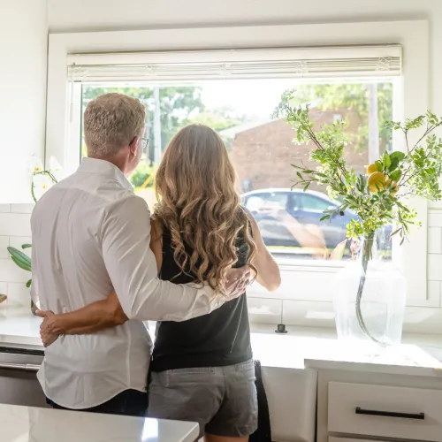a man and a woman standing in front of a window