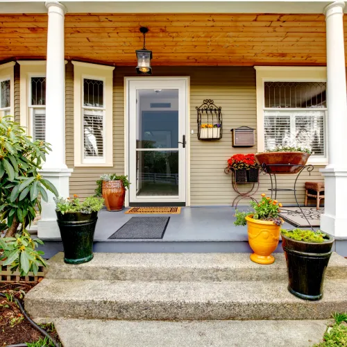 the front porch of a home with a white door