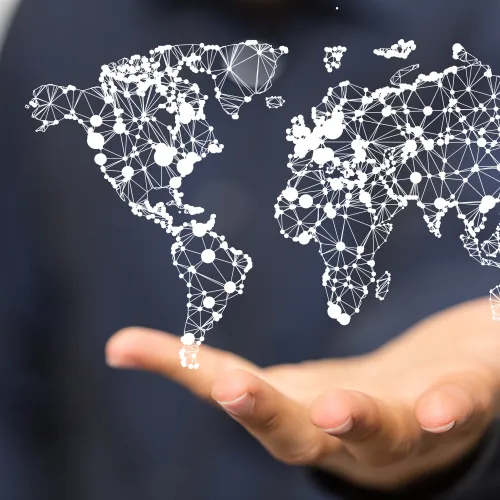 Hand holding a digital network map of the world representing global connectivity and communication.