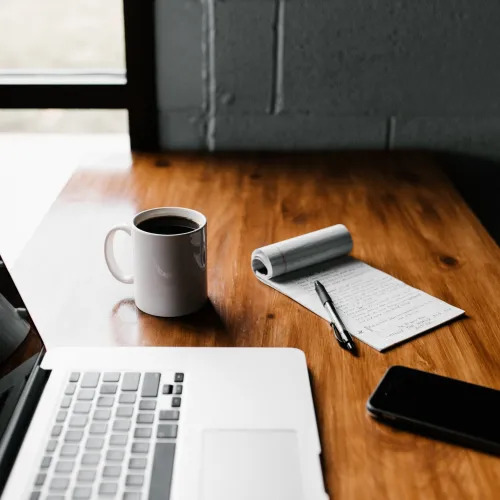 a desk with a laptop and a phone on it