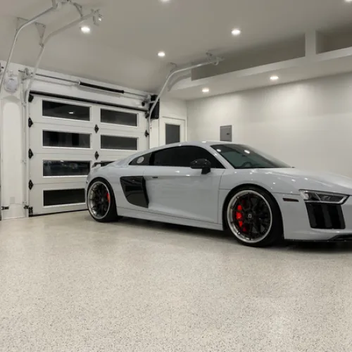 a white sports car parked in a large room with white walls