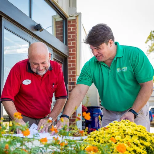 a couple of men looking at flowers