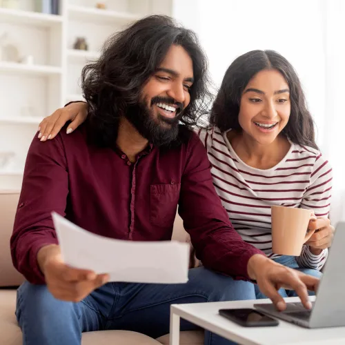 a man and a woman looking at a laptop