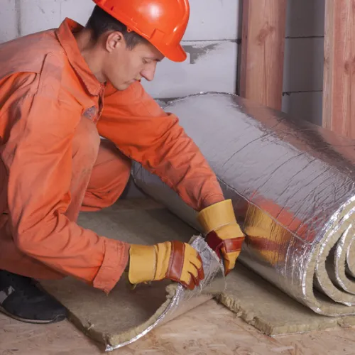 a person in orange protective gear fixing a car tire