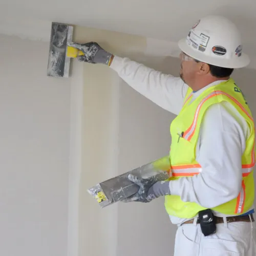 a person wearing a hard hat and safety vest holding a piece of paper