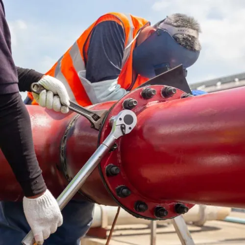 a person in a protective gear working on a red car