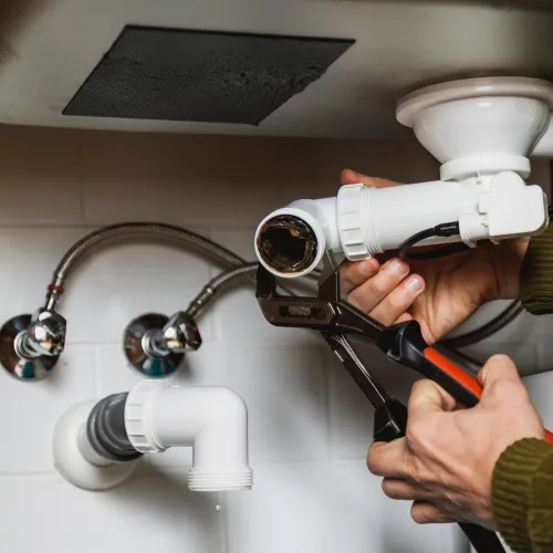 a person holding a hose to a faucet