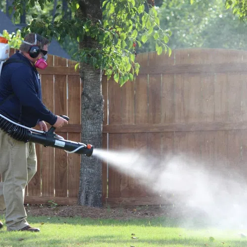 man spraying yard for mosquitoes