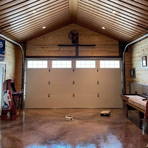 a room with a large door and a wood floor with a person standing in front of it