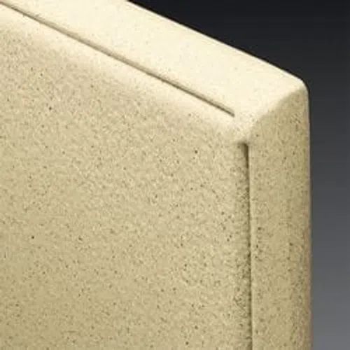 Close-up of a beige textured foam panel with a smooth groove on the upper edge against a dark background