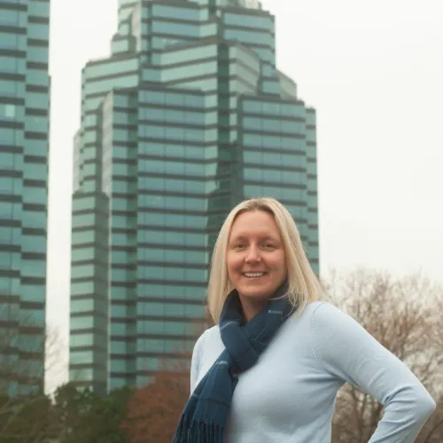 a woman smiling in front of a building
