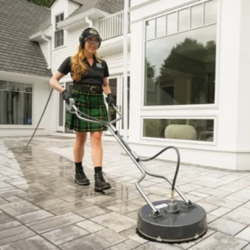 a person in a kilt washing a patio