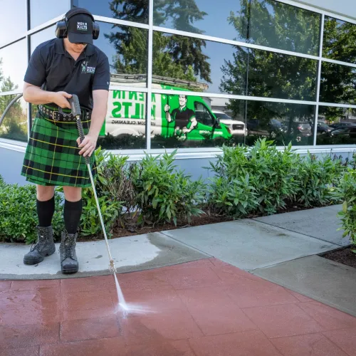 a person wearing a kilt and holding a pressure wand
