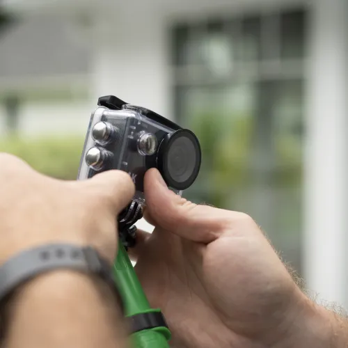 a person holding a gutter camera