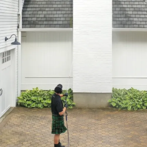 a person soft washing a house