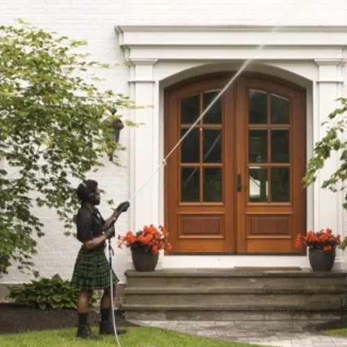 a person in a kilt holding a cane in front of a house