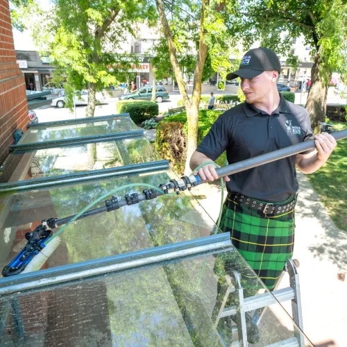 a person in a kilt washing a window