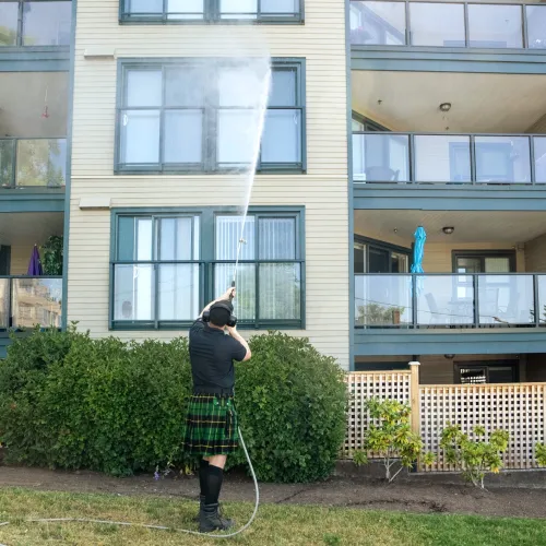 a person in a kilt standing in front of a building