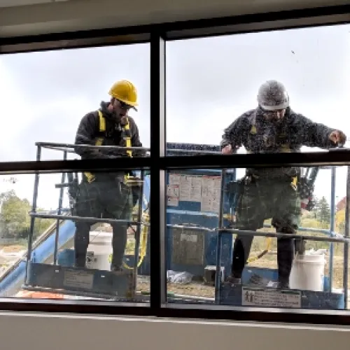 a couple of men in uniform looking out a window