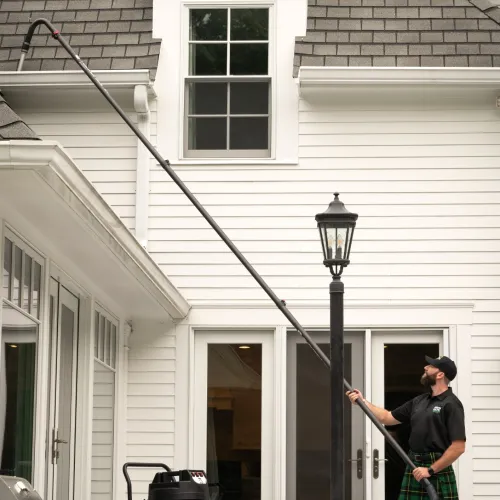 a man in a kilt using cleaning a gutter