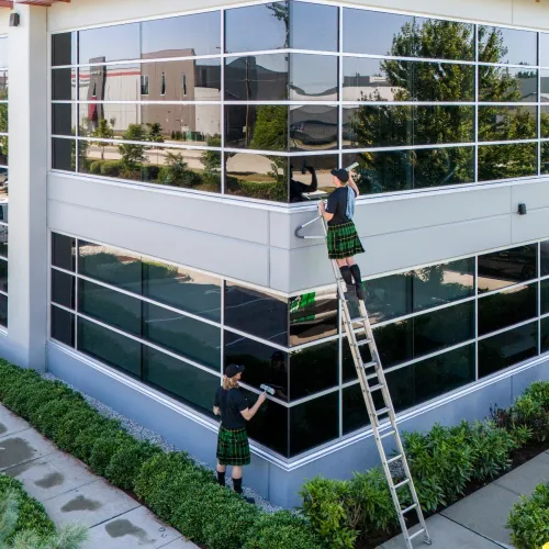 a couple of people washing windows on a building