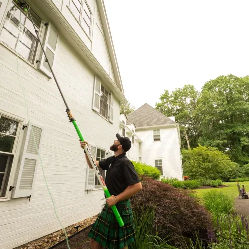 a man holding a broom outside a house