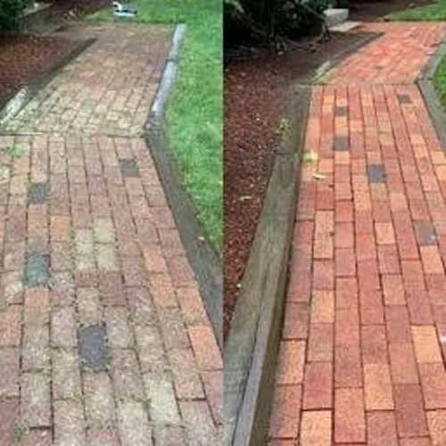 a brick walkway with grass and a brick path