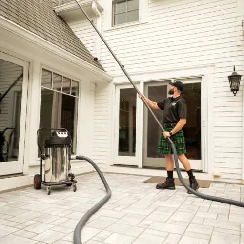 a man holding a gutter vacuum