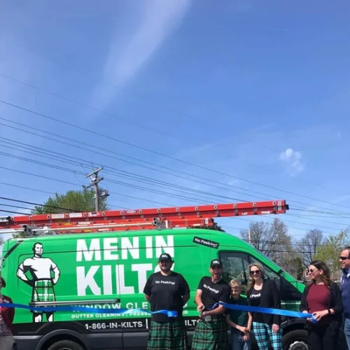 a group of people standing next to a green bus