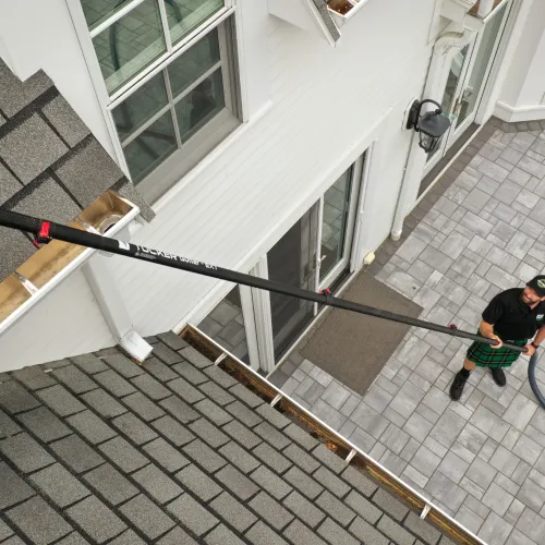 a person cleaning gutters standing on a patio