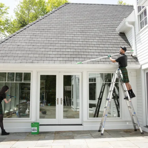 a person on a ladder painting a house