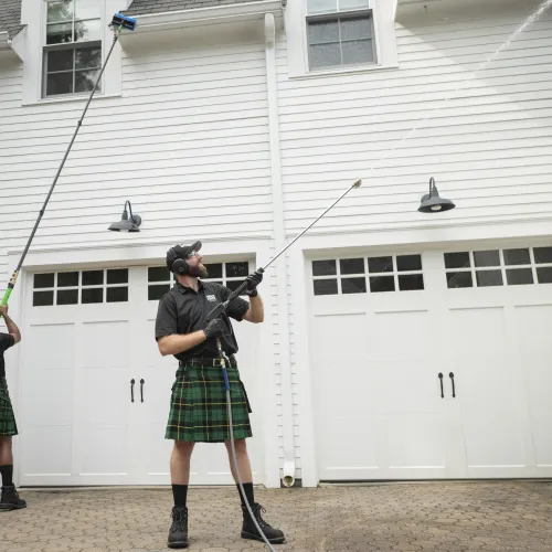a person in a kilt holding a gun in front of a white building