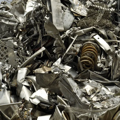 A close-up of crushed and twisted scrap metal pieces with visible springs and various twisted shapes.