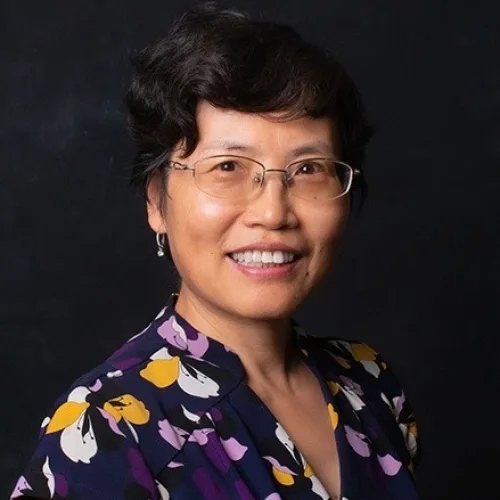 a person wearing a purple shirt and smiling at the camera