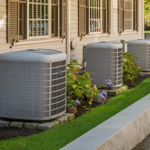 a group of metal air conditioning units outside a house in [city, state]
