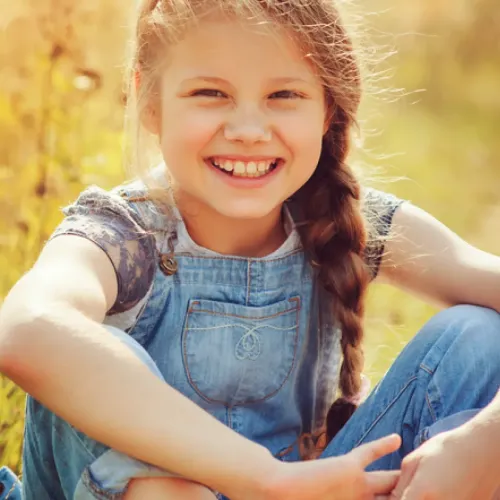 a girl sitting in a field