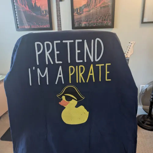 A playful navy blue shirt featuring a rubber duck and the text 'Pretend I'm a Pirate' in a fun font.