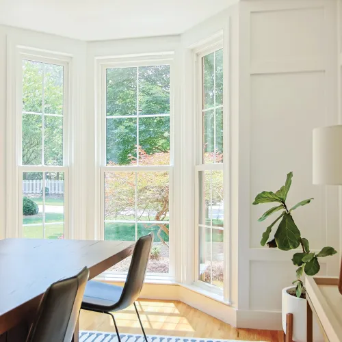 a room with a table and chairs and white fiberglass windows
